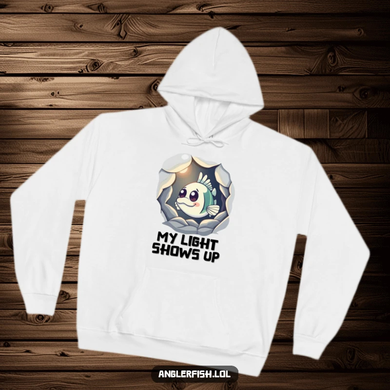 Funny Anglerfish Hoodie featuring a curious anglerfish peeking from a shadowy cave, its light casting a glow, perfect for cozy mystery.
